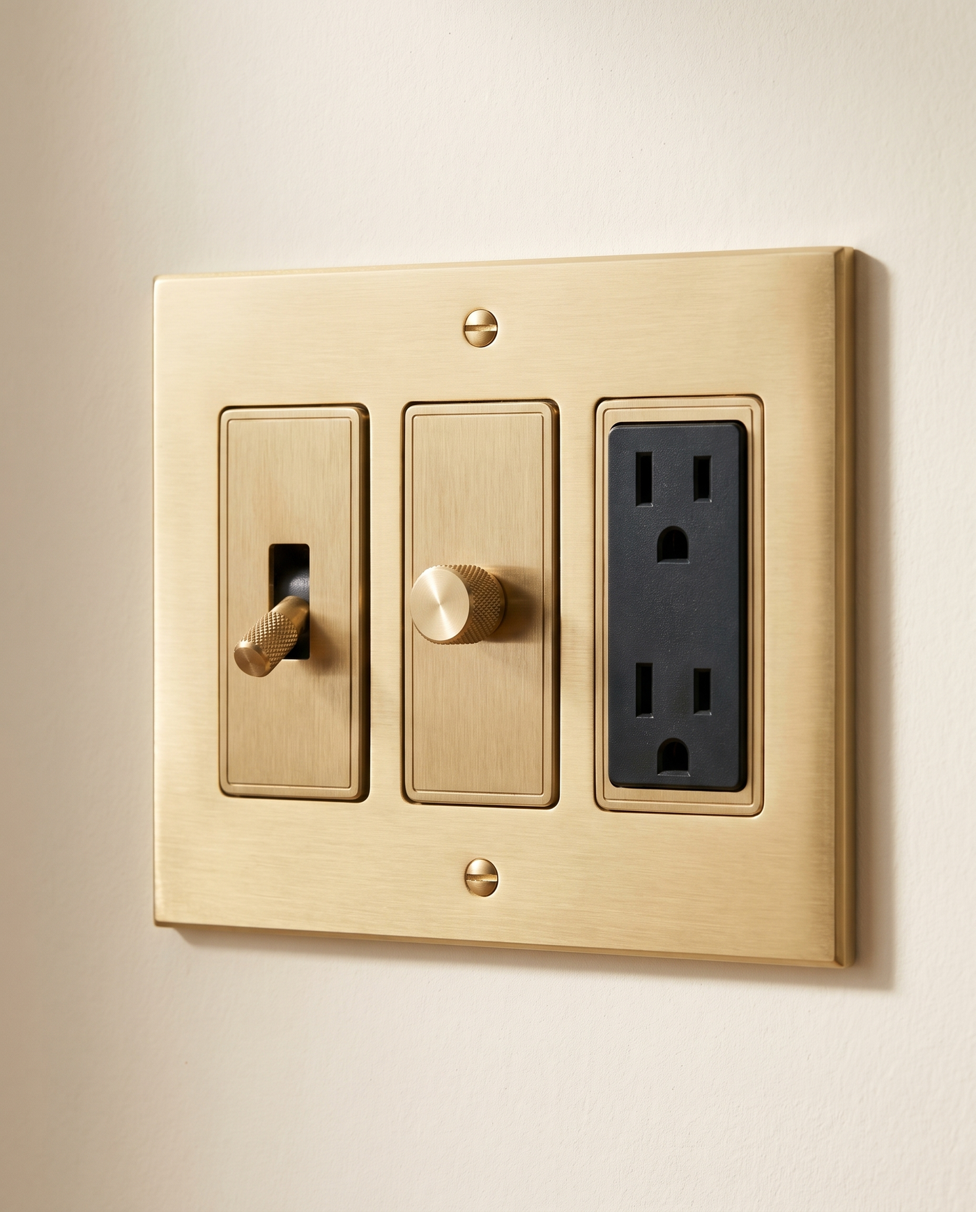 Brio Build Your Own Brass Switch in brushed brass, packshot on warm ivory plaster