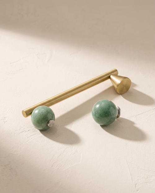 Avena green stone sphere knob and brass cone pull, packshot on warm ivory plaster