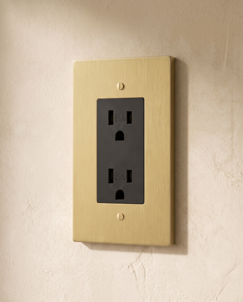 Brio Brass Outlet in brushed brass, packshot on warm ivory plaster
