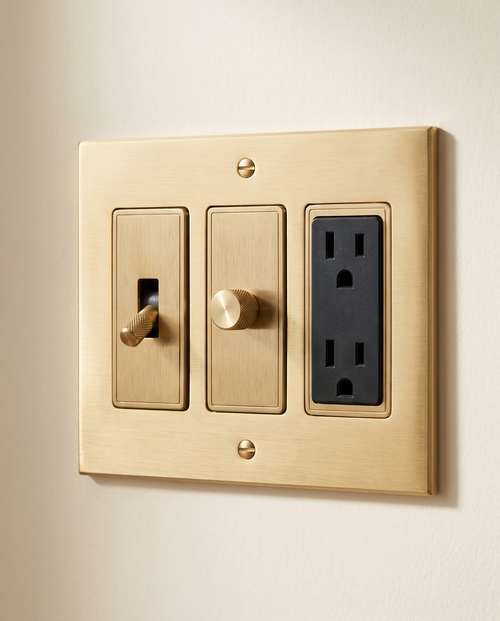Brio Build Your Own Brass Switch in brushed brass, packshot on warm ivory plaster